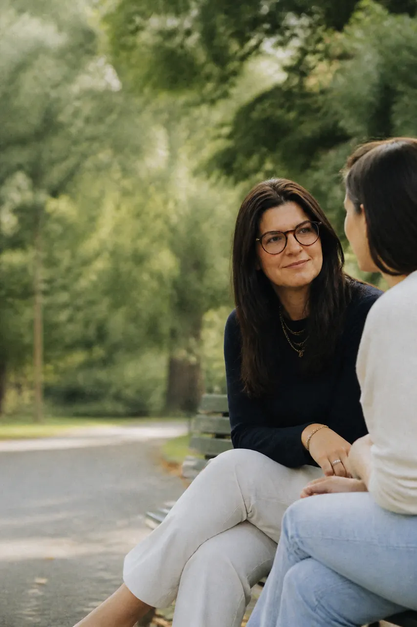 Duas pessoas conversando sentadas, em um ambiente calmo